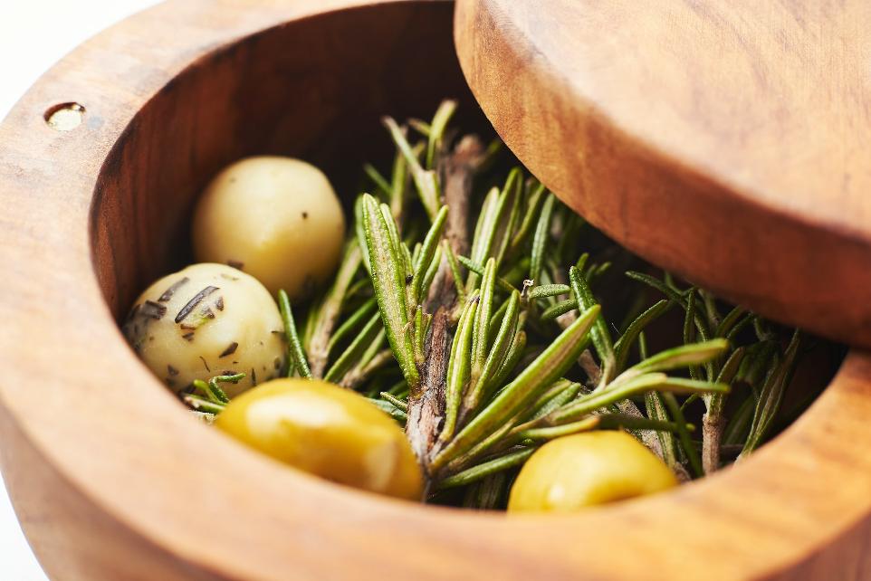 a wooden bowl filled with green and yellow tomatoes